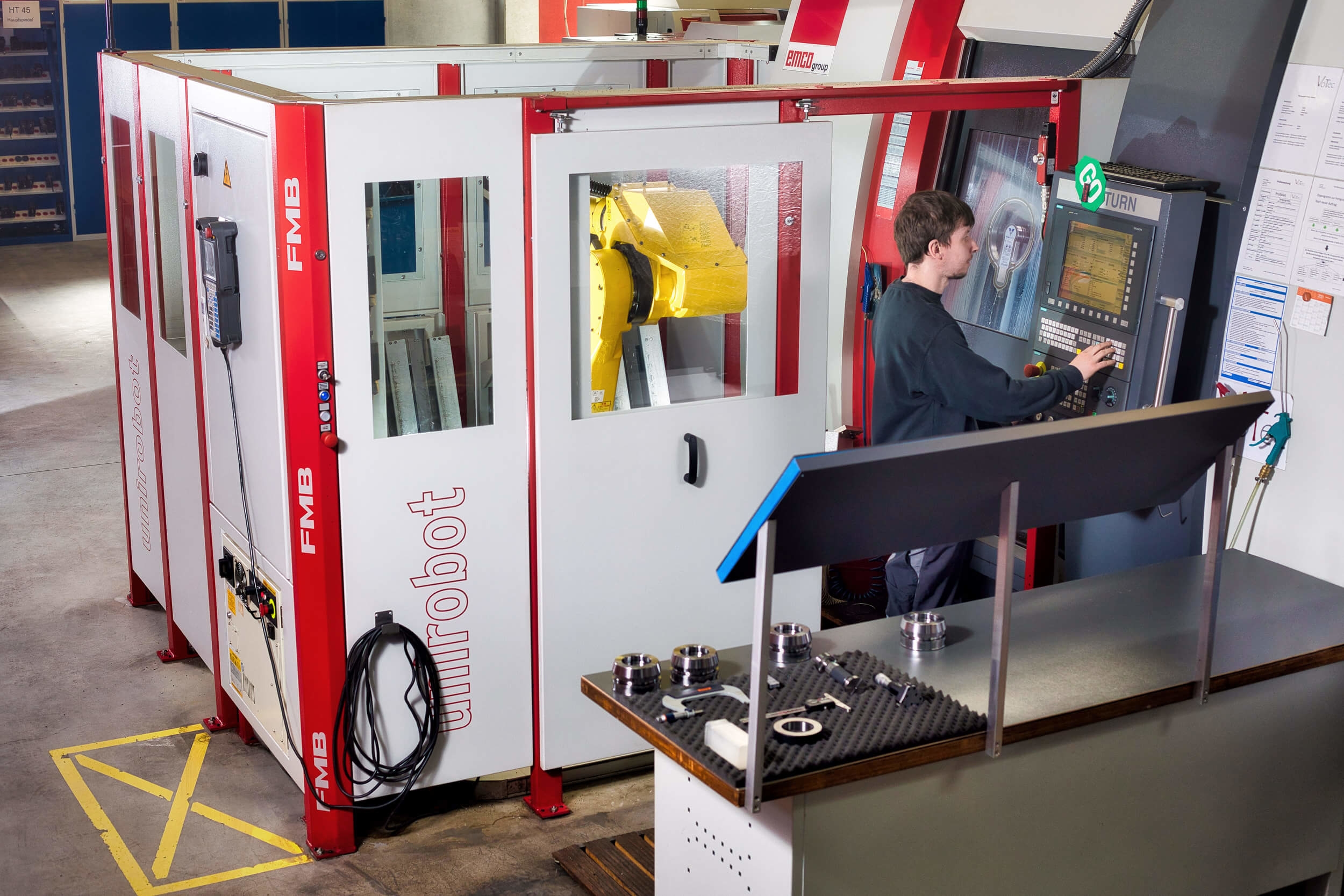 Mitarbeiter bedient Roboterzelle - VoTec - CNC-Drehen und Fräsen